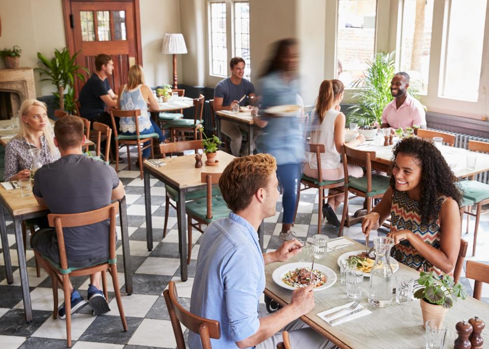 Customers enjoying meals in busy restaurant.