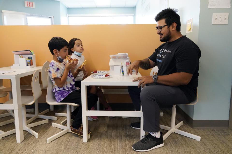 Program Director Alan Arce, right, chats with siblings Moises, left, and Yancy Rodriguez at a Friends of the Children office Wednesday, Aug. 24, 2022, in Lancaster, Calif. Billionaire philanthropist MacKenzie Scott donated $44 million to the Oregon-based mentoring organization, Friends of the Children, which supports children at risk of entering the welfare system by pairing them with a longtime mentor. (AP Photo/Marcio Jose Sanchez)