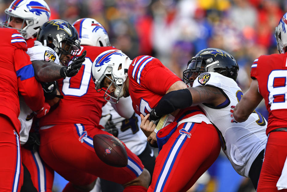 Buffalo Bills quarterback Josh Allen, center, has the ball knocked loose as he is hit by Baltimore Ravens outside linebacker Matt Judon (99), right, during the first half of an NFL football game in Orchard Park, N.Y., Sunday, Dec. 8, 2019. The fumble was recovered by Ravens defensive end Jihad Ward. (AP Photo/Adrian Kraus)