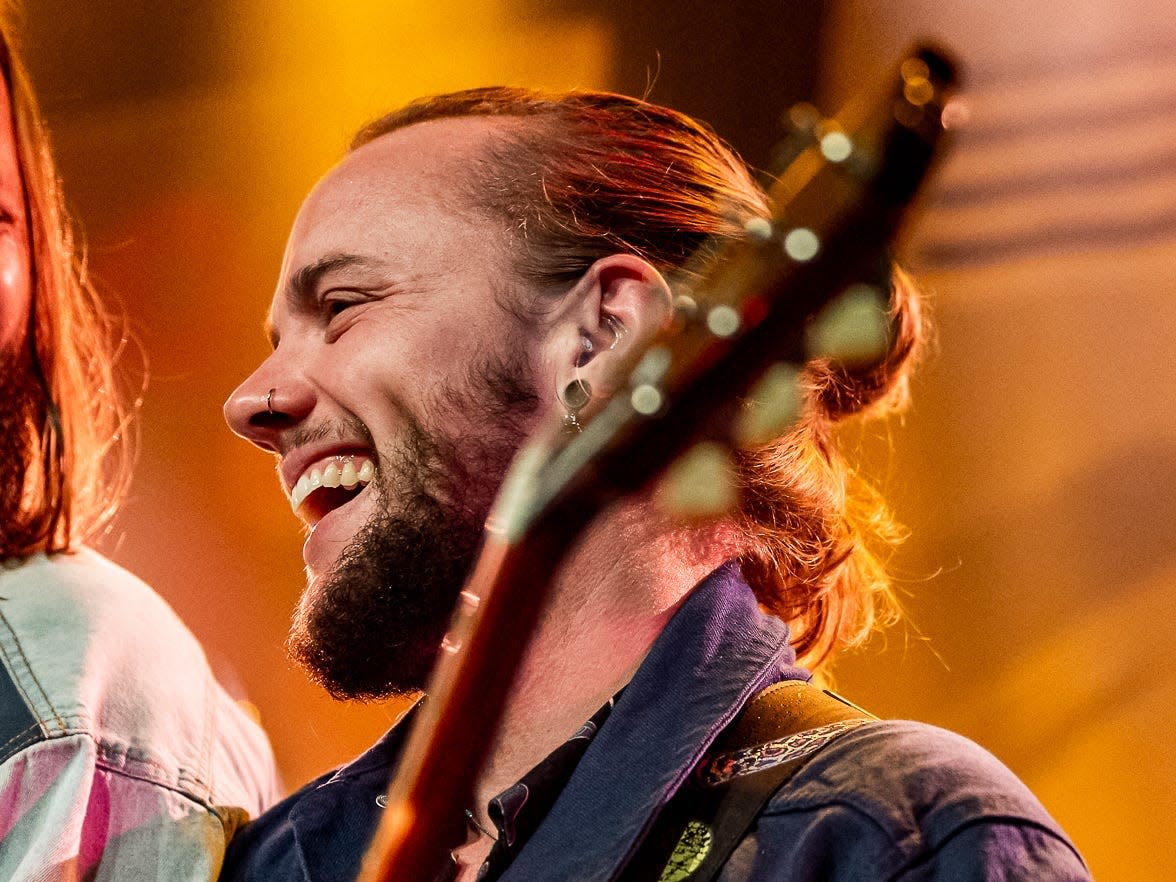 Sem Jansen laughing and playing guitar with his bandmate