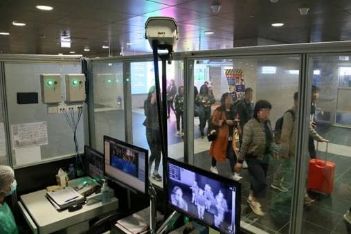 Officials monitor thermal scanners at a temperature monitoring station at Taipa Ferry Terminal in Macau