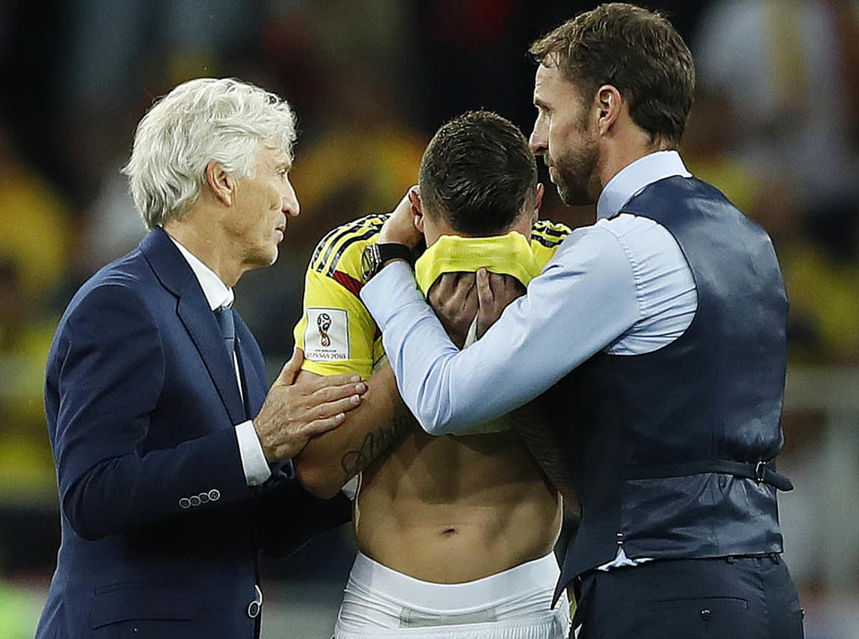 Colombia head coach Jose Pekerman, left, and England head coach Gareth Southgate, right, comfort Colombia’s Mateus Uribe. (AP Photo/Alastair Grant)