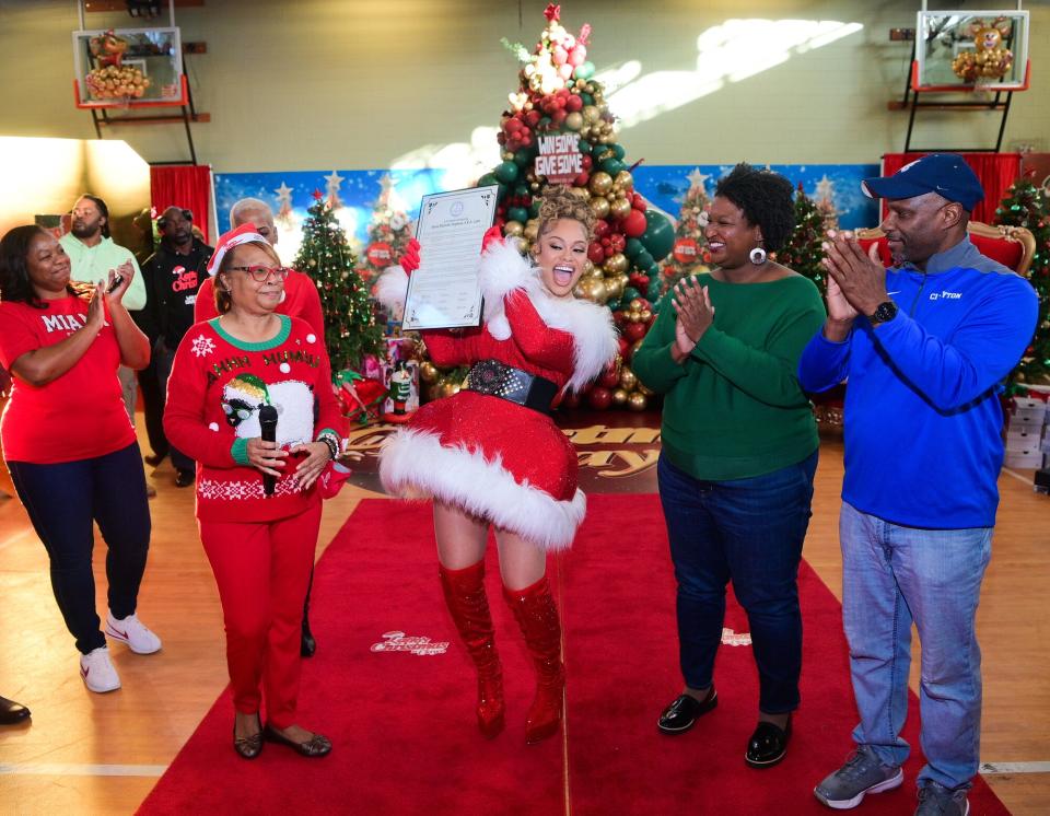 Jessie Goree (L), Latto (C) and Stacey Abrams (2nd from R) attend Latto "Christmas In Clayco" at Carl Rhodenizer Recreation Center on December 18, 2022 in Jonesboro, Georgia.