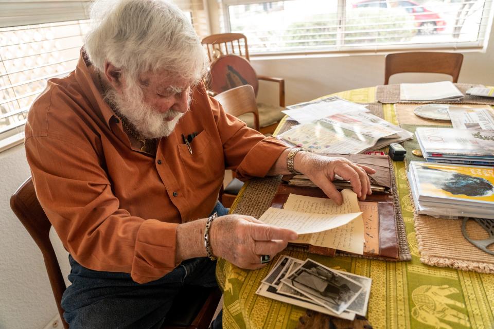 Werner Salinger, 90, a U.S. Air Force Intelligence veteran who enlisted during the Korean War, sorts through photographs and letters written by his wife, Martha Salinger, 89, at their home in Gold Canyon on Jan. 13, 2023.