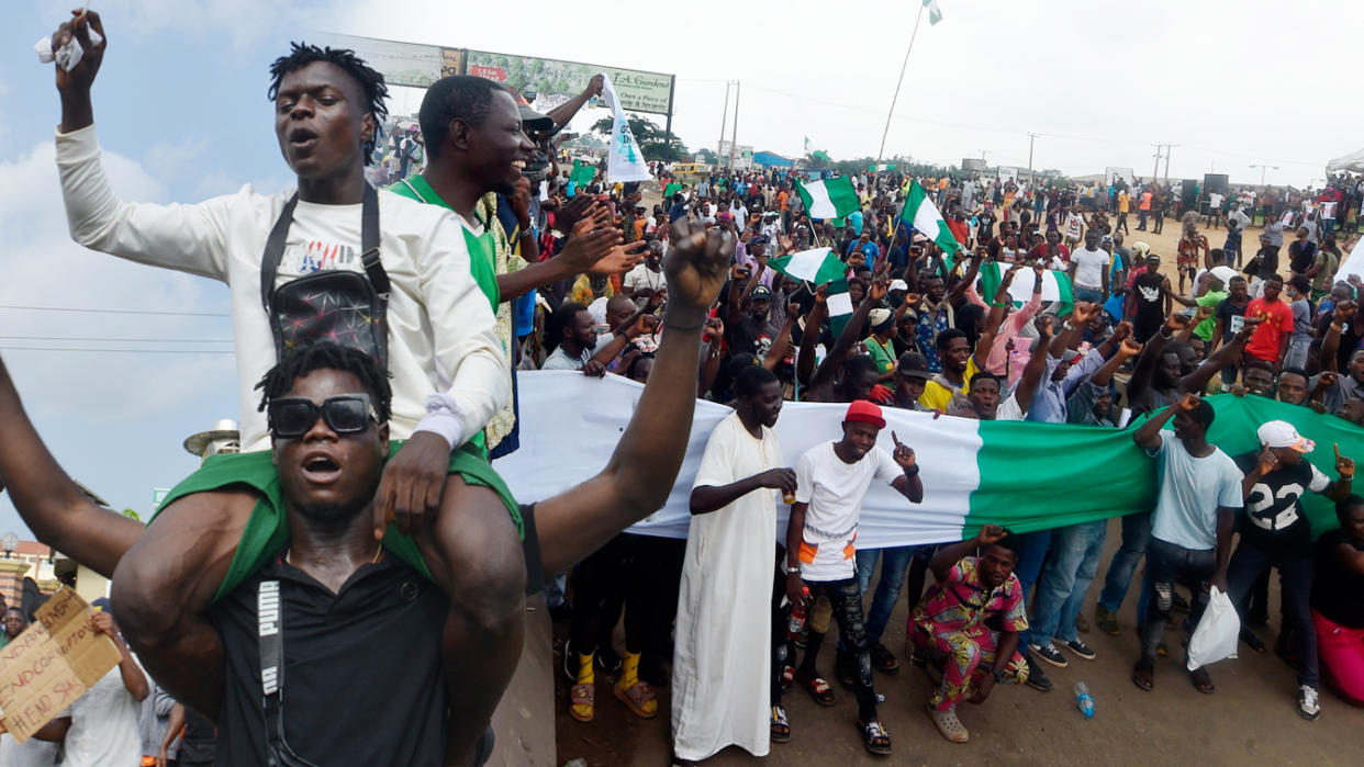 Protesters march at Alausa Secretariat in Ikeja, Lagos State, during a peaceful demonstration against police brutality in Nigeria.  (Photo Illustration: Yahoo News; Photos: Getty Images (2))