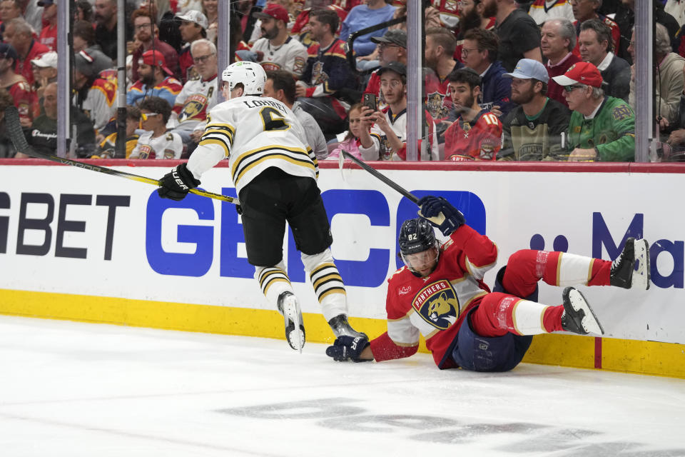 Boston Bruins defenseman Mason Lohrei (6) leaves Florida Panthers center Kevin Stenlund (82) after slamming him against the boards during the first period of Game 1 of the second-round series of the Stanley Cup Playoffs, Monday, May 6, 2024, in Sunrise, Fla. (AP Photo/Wilfredo Lee)