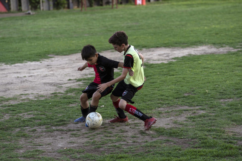 Children fight for the ball during training at a football school at Newell's All Boys club, where Lionel Messi played as a kid in Rosario, Argentina, Wednesday, Dec.14, 2022. (AP Photo/Rodrigo Abd)
