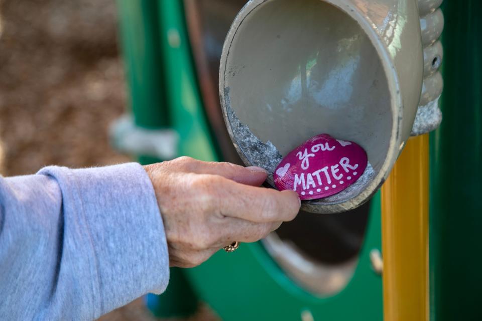 Tiffany Jendrzejczyk hides a shell that she painted on the playground on Sanibel Island on Thursday, Feb. 8, 2024.