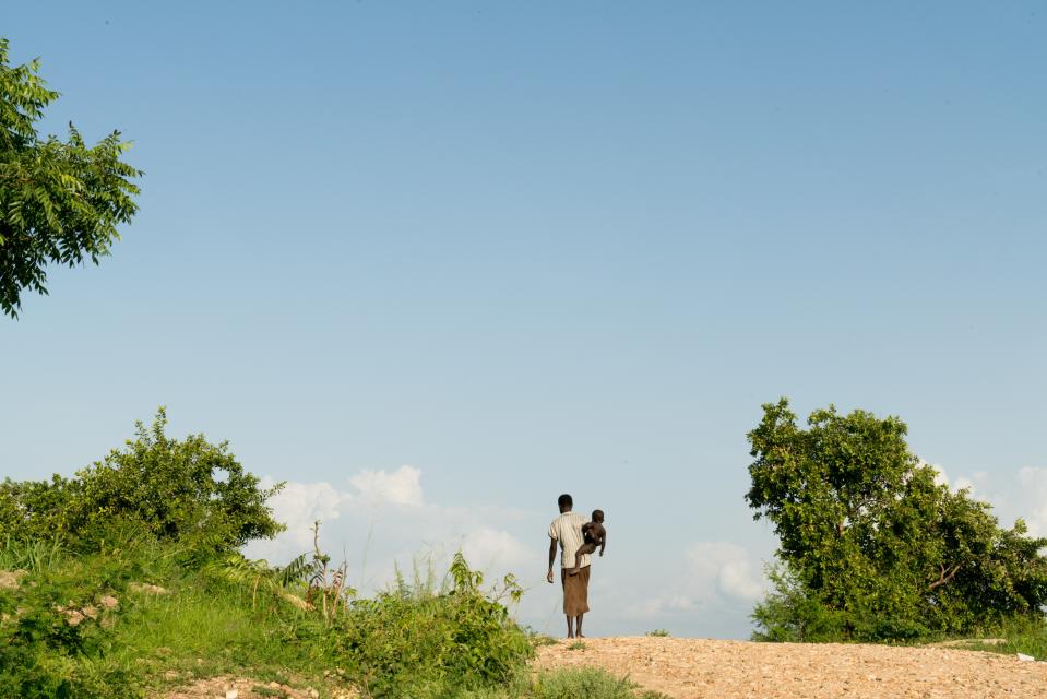 A woman walks with a child in the Omugo settlement for refugees who have fled from South Sudan to Uganda, June 27, 2019.