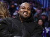 FILE - Kanye West watches the first half of an NBA basketball game between the Washington Wizards and the Los Angeles Lakers in Los Angeles, on March 11, 2022. Former President Donald Trump had dinner Tuesday, Nov. 22, at his Mar-a-Lago club with the rapper formerly known as Kanye West, who is now known as Ye, as well as Nick Fuentes, a far-right activist who has used his online platform to spew antisemitic and white supremacist rhetoric. (AP Photo/Ashley Landis, File)