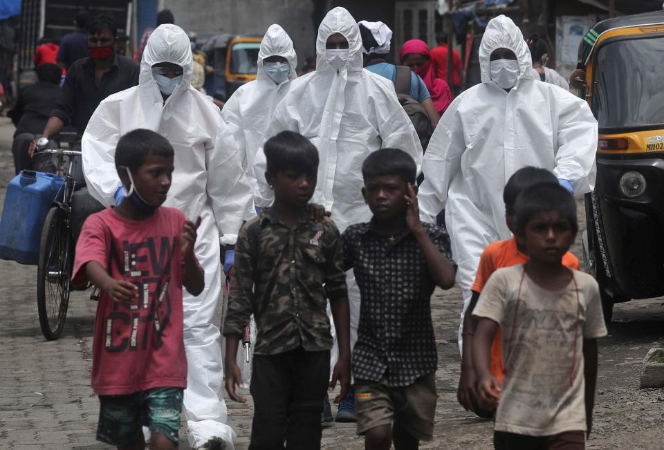 Trabajadores de salud llegan para examinar personas en busca de síntomas de COVID-19 en un barrio de Mumbai, India, el viernes 10 de julio de 2020. (AP Foto/Rafiq Maqbool)