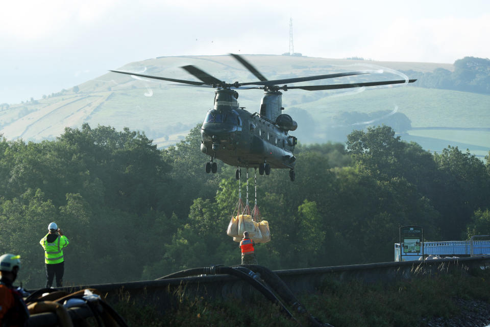An RAF Chinook helicopter flies in sandbags to help repair the dam at Toddbrook reservoir near the village of Whaley Bridge in Derbyshire after it was damaged by heavy rainfall. PRESS ASSOCIATION Photo. Picture date: Friday August 2, 2019. See PA story WEATHER Rain. Photo credit should read: Yui Mok/PA Wire