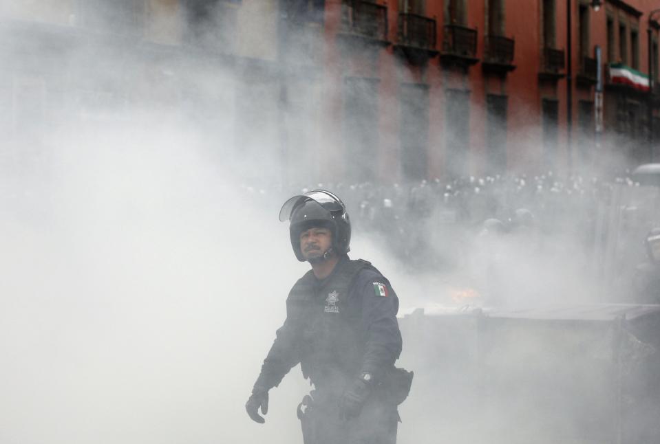 A police officer stands amid smoke during protests near the Zocalo in Mexico City September 13, 2013. ( REUTERS/Tomas Bravo)