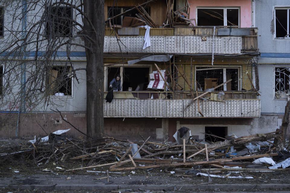 A man cleans up the balcony of an apartment of a residential building that was heavily damaged after a Russian attack last week in Zaporizhzhia, Ukraine, Sunday, Oct. 16, 2022. (AP Photo/Leo Correa)