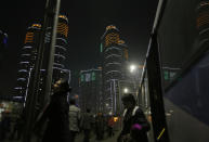 In this Tuesday Feb. 25, 2014 photo, North Koreans get off a bus at a residential complex which is lit at night in Pyongyang, North Korea. (AP Photo/Vincent Yu)