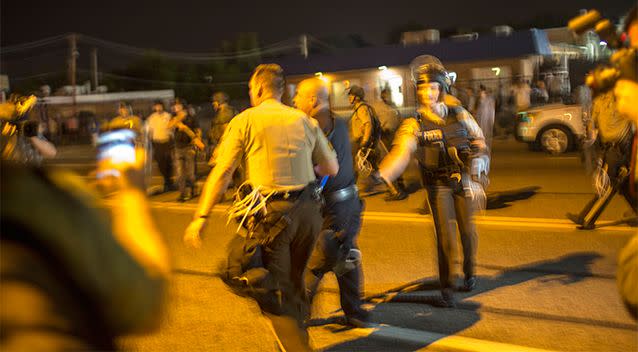 Missouri police officer Lt. Ray Albers is led away by a superior officer after pointing an assault rifle at a protester of the death of teenager Michael Brown. Photo: Getty Images