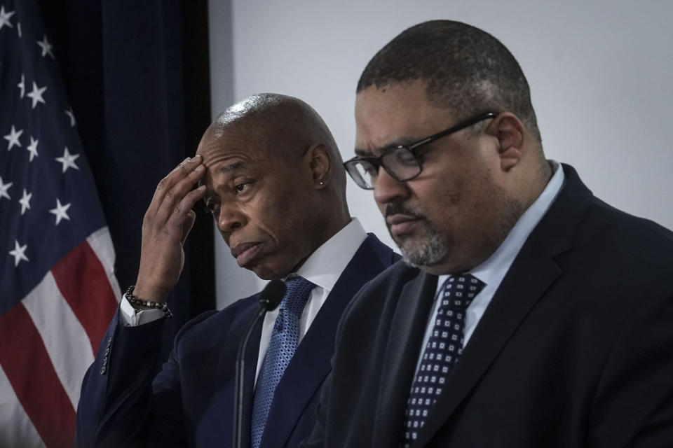 Mayor Eric Adams, left, and District Attorney Alvin Bragg, right, listen during a press conference where they announced several charges for migrants involved in a Times Square brawl with police, Thursday, Feb. 8, 2024, in New York. (AP Photo/Bebeto Matthews)