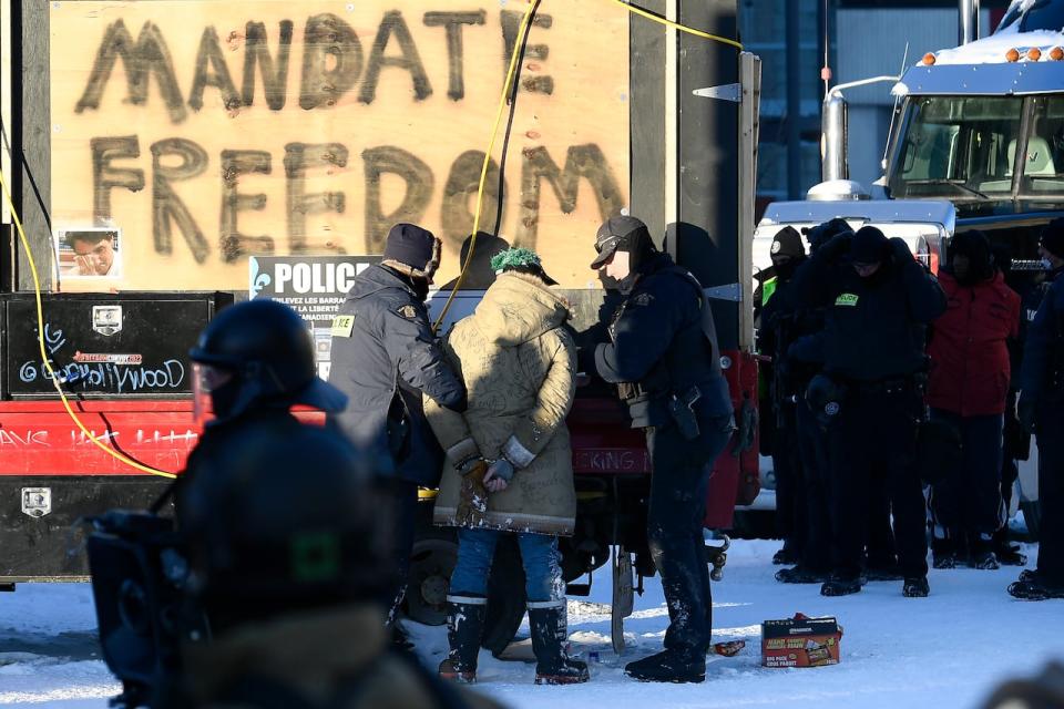 In this file February 2022 photo, RCMP officers take a protester into custody at the Ottawa anti-vaccine mandate protest.