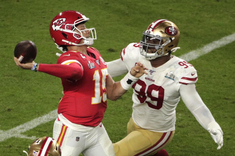 Kansas City Chiefs quarterback Patrick Mahomes (15) aims a pass to Tyreek Hill (10) as San Francisco 49ers' DeForest Buckner (99) attempts to defend, during the second half of the NFL Super Bowl 54 football game Sunday, Feb. 2, 2020, in Miami Gardens, Fla. (AP Photo/Charlie Riedel)
