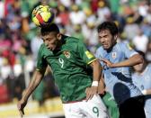 Yasmani Duk (L) of Bolivia heads the ball over Alvaro Gonzalez of Uruguay during their 2018 World Cup qualifying soccer match at the Hernando Siles Stadium in La Paz, Bolivia October 8, 2015. REUTERS/David Mercado