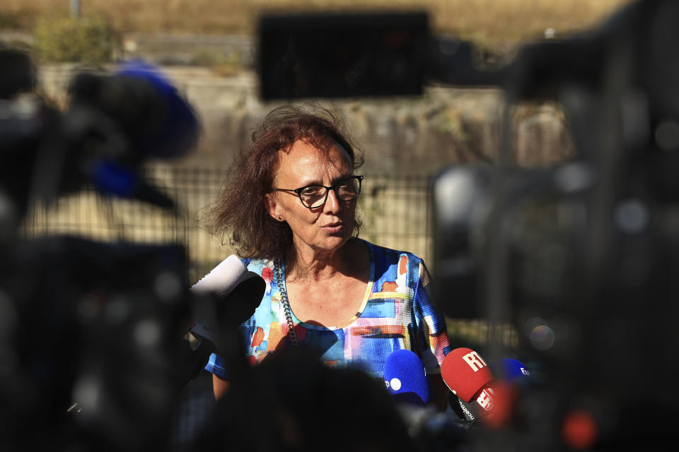 Isabelle Dorliat Pouzet, deputy prefect of the town of Evreux speaks to the media near the lock of Notre Dame de la Garenne where a Beluga whale is being prepared to be moved, in Saint-Pierre-la-Garenne, west of Paris, France, Tuesday, Aug. 9, 2022. French environmentalists are moving a dangerously think Beluga that had strayed into the Seine River last week to a salt-water river basin to try and save its life. The whale would remain in its temporary saltwater home for "two to three days" of surveillance and treatment before being towed out to sea, according to Isabelle Dorliat Pouzet, deputy prefect of the town of Evreux. (AP Photo/Aurelien Morissard)