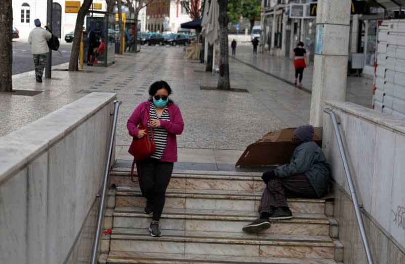 A woman wearing a protective mask as a preventive measure against coronavirus disease (COVID-19) enters the subway at Rossio Square in downtown Lisbon