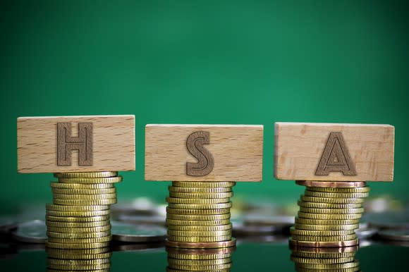 Piles of coins with letter-blocks spelling out HSA.