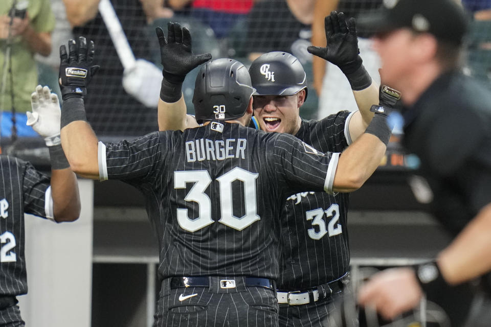 Chicago White Sox's Gavin Sheets (32) high-fives Jake Burger (30) after Burger hit a home run during the sixth inning of a baseball game against the Cleveland Guardians, Friday, July 28, 2023, in Chicago. (AP Photo/Erin Hooley)