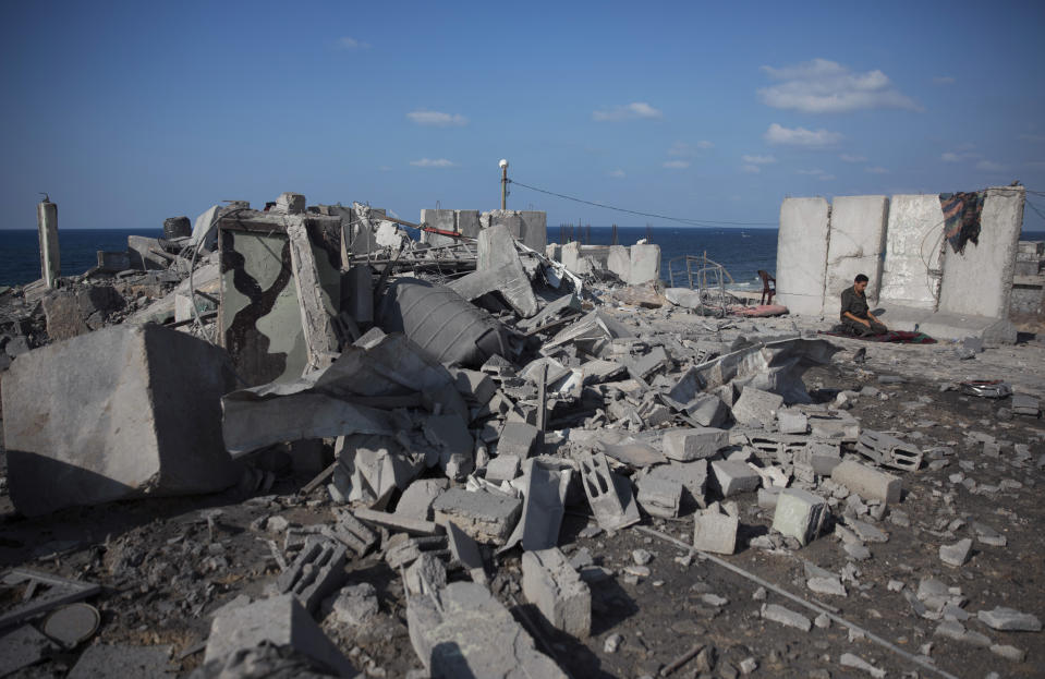 A Palestinian Hamas national security soldier prays next to the rubble of a destroyed military base following Israeli airstrikes, in the town of Rafah, southern Gaza Strip, Wednesday, Oct. 17, 2018. (AP Photo/ Khalil Hamra)