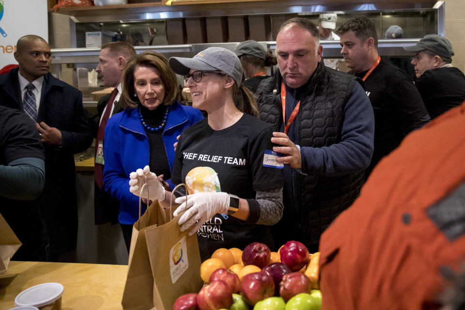 House Speaker Nancy Pelosi of Calif., center left, and Chef Jose Andres, center right, arrive to give out food at World Central Kitchen, the not-for-profit organization started by Chef Jose Andres, Tuesday, Jan. 22, 2019, in Washington. The organization devoted to providing meals in the wake of natural disasters, has set up a distribution center just blocks from the U.S. Capitol building to assist those affected by the government shutdown. (AP Photo/Andrew Harnik)