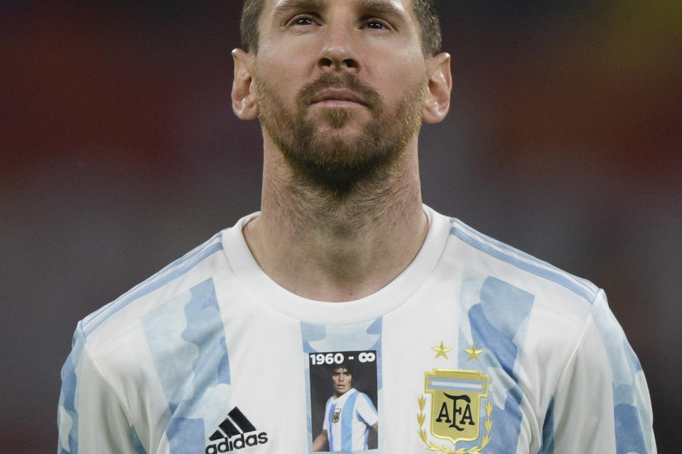 Argentina's Lionel Messi wears a jersey with the number and image of late soccer star Diego Maradona prior to a FIFA World Cup Qatar 2022 qualifying soccer match against Chile in Santiago del Estero, Argentina, Thursday, June 3, 2021. (Juan Mabromata, Pool via AP)