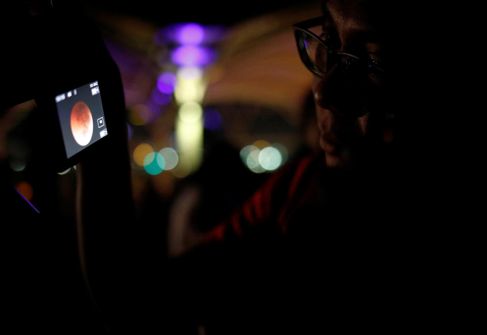 <p>An astronomy enthusiast takes a photo of the lunar eclipse of a blood moon at Marina South Pier in Singapore July 28, 2018. REUTERS/Edgar Su </p>