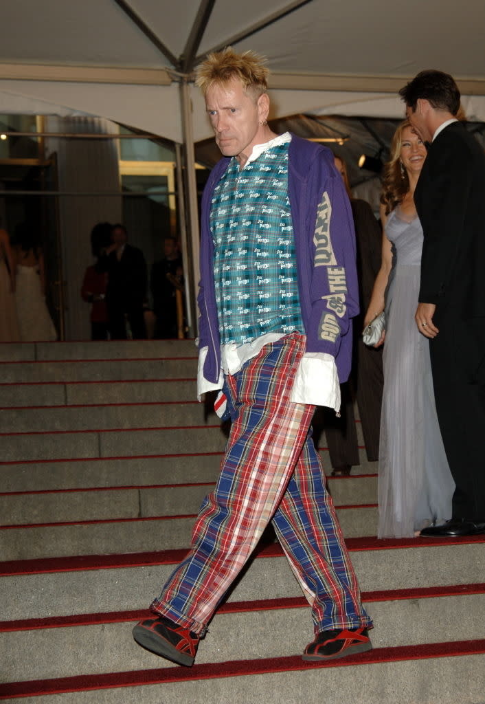 John in eclectic outfit with plaid pants and layered tops on red carpet