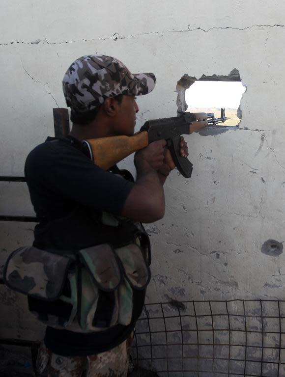 A member of the Popular Mobilisation unit monitors movement by Islamic State group jihadists in the city of Tikrit on March 5, 2015, from his position in the village of Awja, Iraq