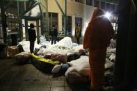 Migrants sleep outside the entrance of the Swedish migration agency's arrival centre in Malmo