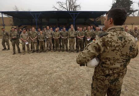 German and British troops listen to a brief before playing a football match to commemorate the Christmas Truce of 1914, at the ISAF Headquarters in Kabul December 24, 2014. REUTERS/Omar Sobhani