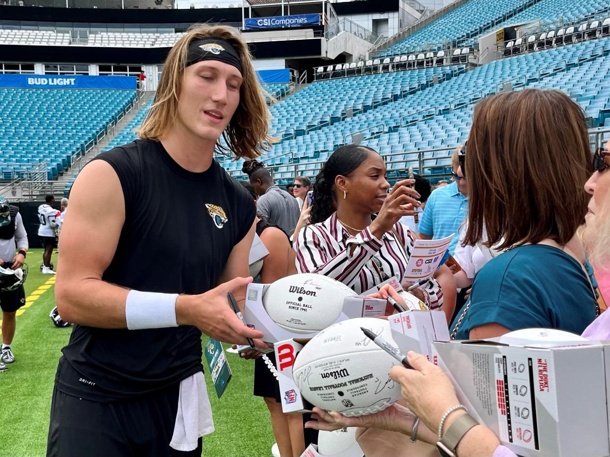 Jaguars quarterback Trevor Lawrence signs autographs for fans who attended the team's Back to Football luncheon at TIAA Bank Field on Tuesday.