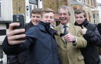 Britain's United Kingdom Independence Party (UKIP) leader Nigel Farage poses for a selfie with voters while out canvasing in Broadstairs, southeastern England April 11, 2015. REUTERS/Suzanne Plunkett