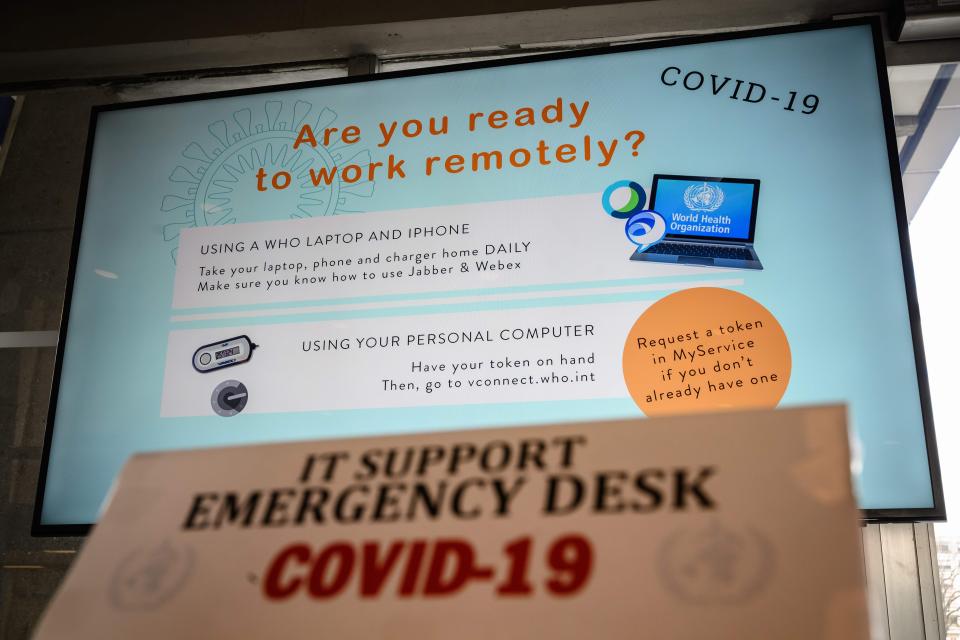 A screen promoting remote working using a laptop and a smartphone is displayed at the World Health Organization headquarters in Geneva to promote the fight against COVID-19, the disease caused by the novel coronavirus, on March 11, 2020 in Geneva. - More governments and companies are encouraging employees to work from home as nations scramble to contain the virus.