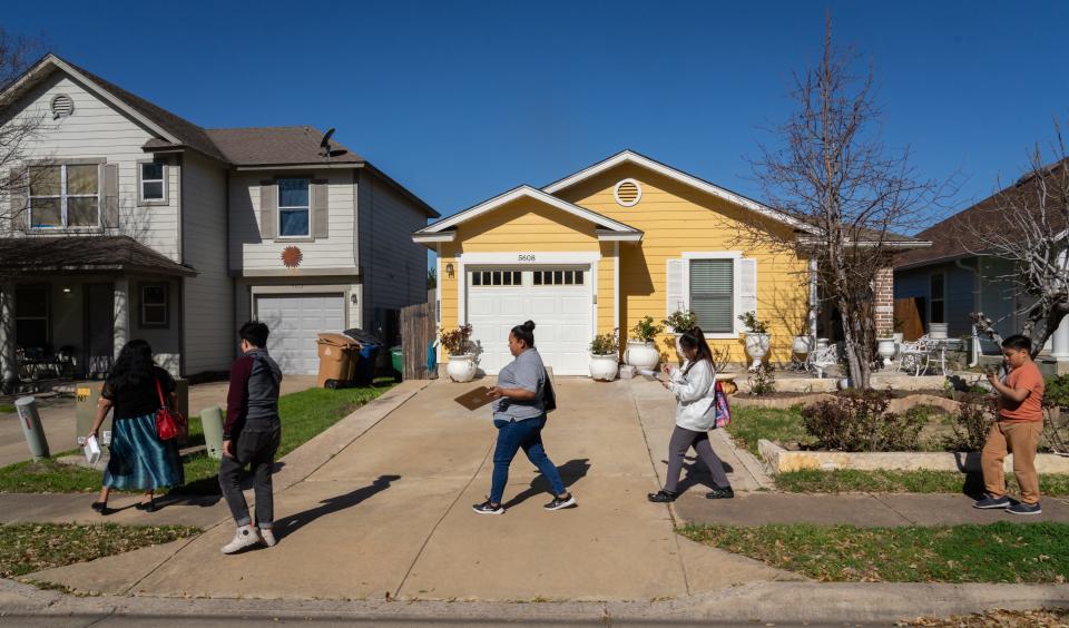 Volunteers and organizers, including Go Austin/Vamos Austin's Erica Reyes, center, visit Del Valle homes to talk about a food co-op.