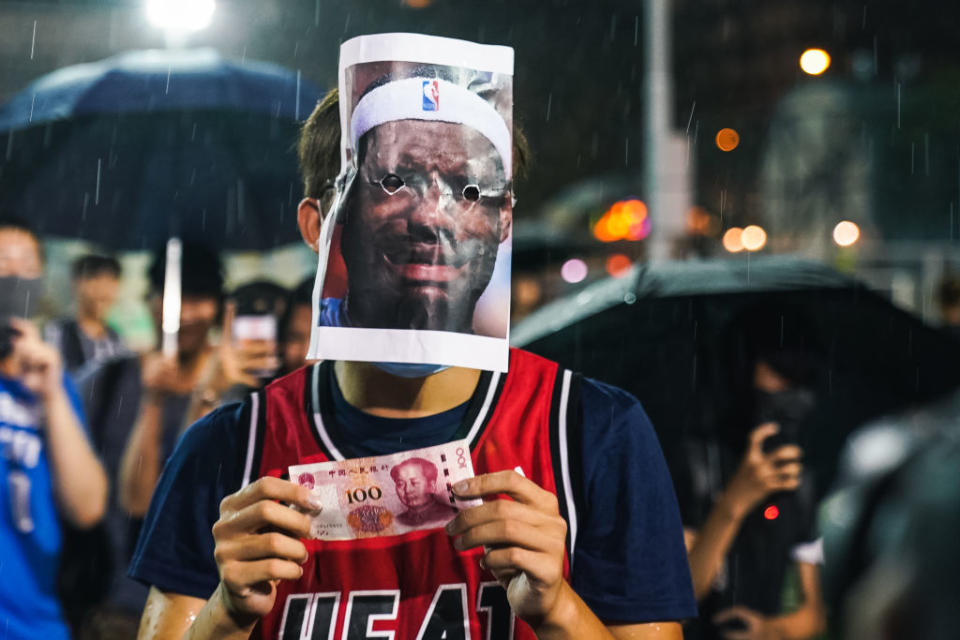 A basketball fan wearing a Miami Heat jersey with a LeBron James mask and a 100 Chinese yuan bill on October 15, 2019 in Southorn Playground, Wan Chai, Hong Kong, China. | Lampson Yip - Clicks Images—Getty Images