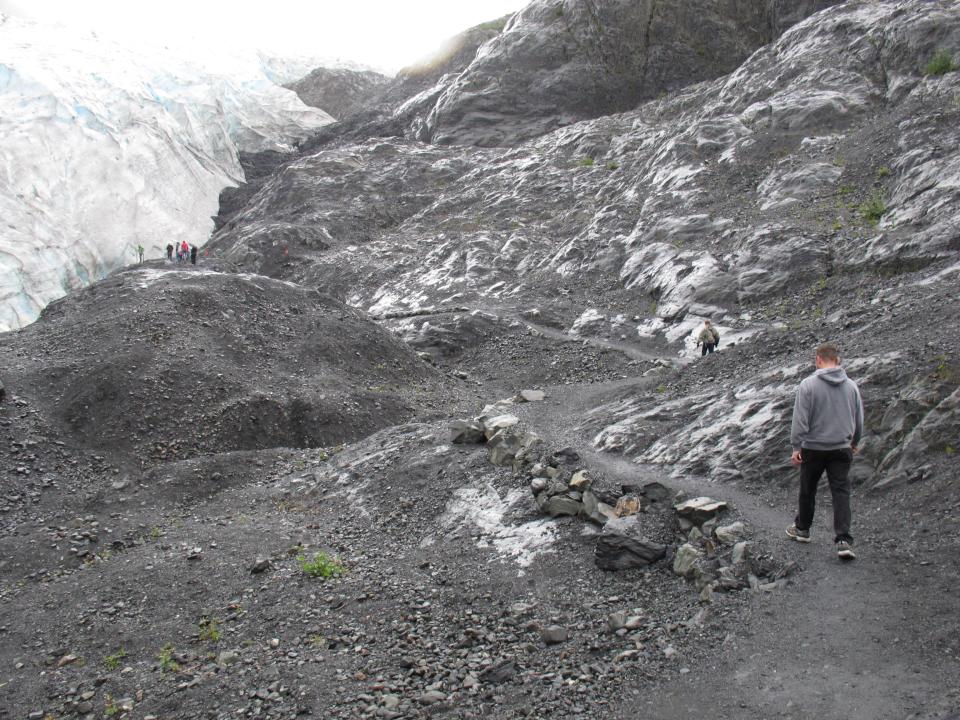 This photo taken Aug. 4, 2012, shows tourists walking to Exit Glacier in Kenai Fjords National Park just outside Seward, Alaska. The glacier is a popular destination for cruise ship passengers visiting the port city of Seward, about 110 miles south of Anchorage, Alaska. (AP Photo/Mark Thiessen)