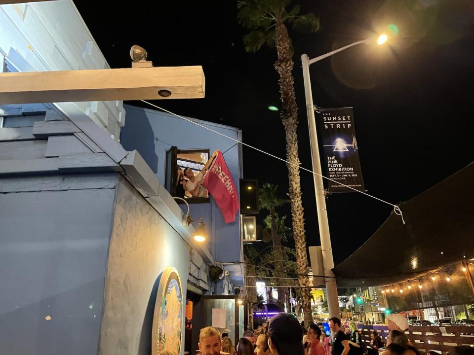 A "Free Britney" supporter dangled a pink flag emblazoned with the movement's hashtag out of a second-floor window at The Naughty Pig in West Hollywood.