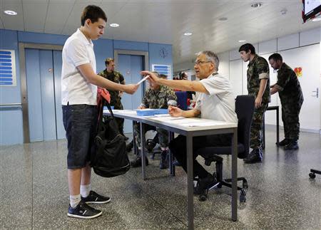 A Swiss man arrives for tests for his military conscription at a recruiting centre in Sumiswald, outside Bern August 27, 2013. REUTERS/Ruben Sprich