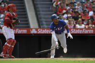 Texas Rangers' Ezequiel Duran, right, runs to first as he hits a three RBI double as Los Angeles Angels catcher Max Stassi watches during the ninth inning of a baseball game Sunday, July 31, 2022, in Anaheim, Calif. (AP Photo/Mark J. Terrill)