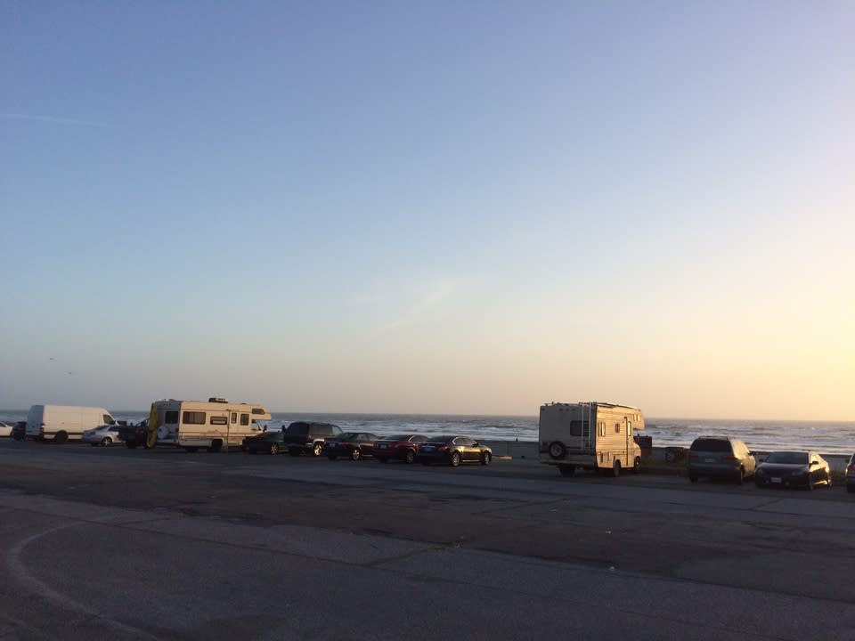Unhoused people living in RVs in the Ocean Beach parking lot.
