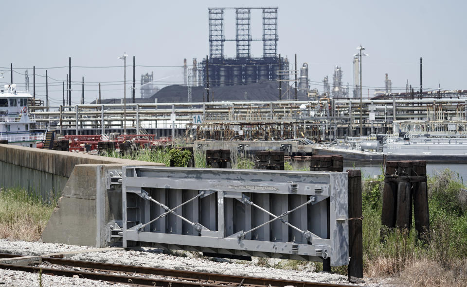 A flood gate and seawall that will be increased in size, is shown near a refinery Thursday, July 26, 2018, in Port Arthur, Texas. The oil industry wants the government to help protect some of its facilities on the Texas Gulf Coast against the effects of global warming. One proposal involves building a nearly 60-mile “spine” of flood barriers to shield refineries and chemical plants. Many Republicans argue that such projects should be a national priority. But others question whether taxpayers should have to protect refineries in a state where top politicians still dispute whether climate change is real. (AP Photo/David J. Phillip)