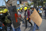 Anti-coup protesters with makeshift shields walk to take positions in Mandalay, Myanmar, Tuesday, March 9, 2021. Demonstrators in Myanmar's biggest city of Yangon came out Monday night for their first mass protests in defiance of an 8 p.m. curfew, seeking to show support for an estimated 200 students trapped by security forces in a small area of one neighborhood. (AP Photo)