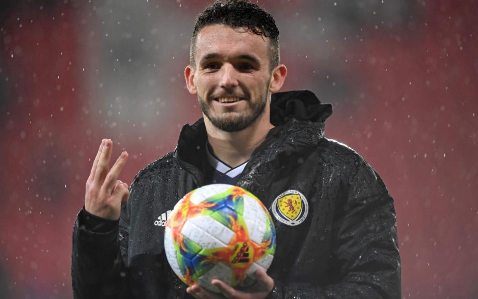 John McGinn claims the match ball after his first-half hat-trick for Scotland - AFP