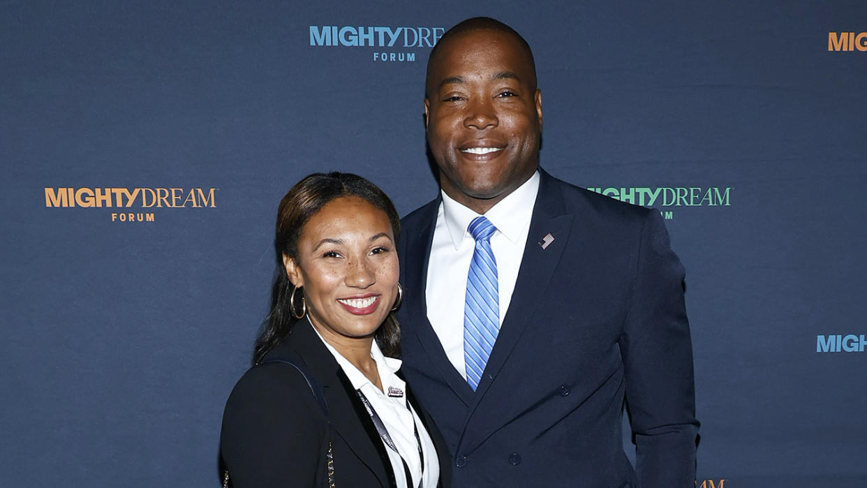 Jennifer Rouse and Aaron Rouse pose in front of a backdrop that reads: Mighty Dream Forum.